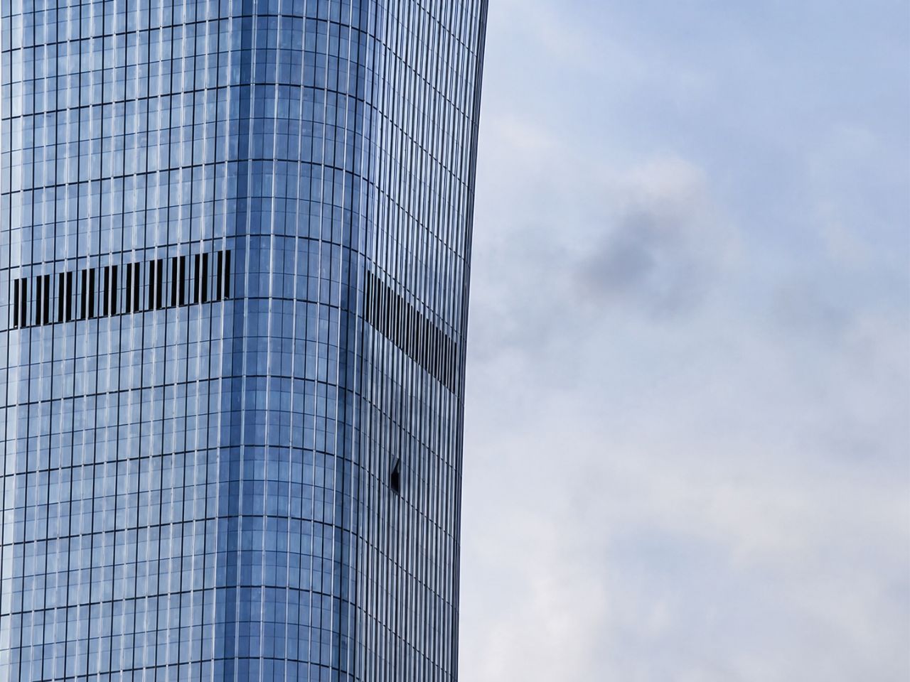 Fachada del CITIC Tower con varias cristaleras afectadas por el impacto de la avioneta.